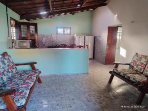 Una sala de estar con dos sillas y una cocina. en hostel xamã, en Flecheiras