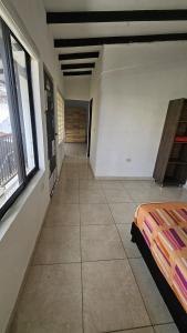 a room with a bed and a hallway with windows at Casa La Eliana in Salento