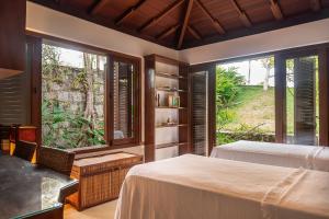 a bedroom with two beds and two windows at Casa Sapucaia Trancoso - Cond. Vale do Segredo in Porto Seguro +63 photos