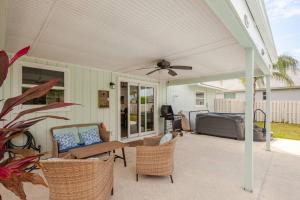 un patio con ventilatore a soffitto, tavolo e sedie. di Costa Bella House a Port Saint Lucie