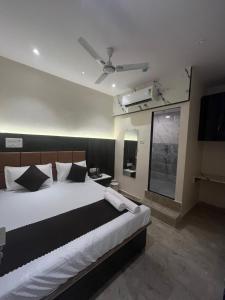 ムンバイにあるHotel Powai Palaceの大きなベッドと薄型テレビのある寝室