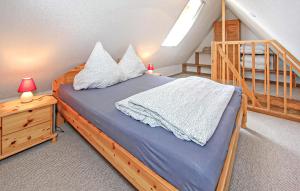a bedroom with a bed with pillows and a staircase at Ferienwohnung Südmüritz in Vipperow