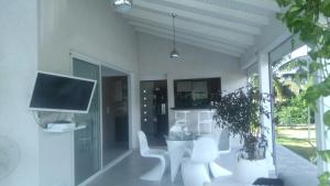 a living room with a tv and a table and chairs at Villa confortable à Sainte-Anne avec piscine privée in Sainte-Anne