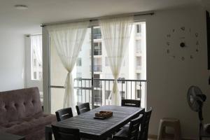 a dining room with a table and a couch and a window at El descanso que mereces,es aquí. in Girardot