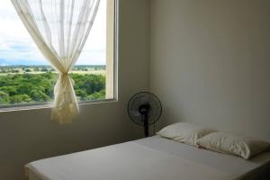 a bed in a room with a window and a fan at El descanso que mereces,es aquí. in Girardot