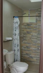 a bathroom with a toilet and a shower curtain at El descanso que mereces,es aquí. in Girardot
