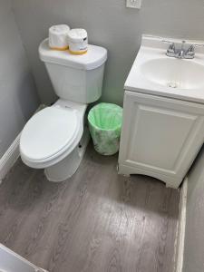 Łazienka z białą toaletą i umywalką w obiekcie Haystack Hostel w mieście Houston