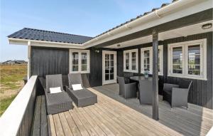 a wooden deck with chairs and a table at Holiday Home Arvidvej Hvide Sande Xii in Bjerregård
