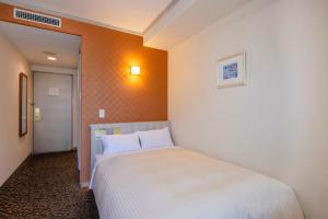 a bedroom with a white bed in a room at Sasebo Washington Hotel in Sasebo