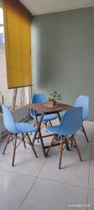 ein Holztisch und zwei blaue Stühle und ein Tisch und Stühle in der Unterkunft Valhalla Planta Baja cerca al Aeropuerto Factura in Valente Díaz y La Loma