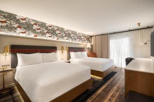 a hotel room with two beds and a sink at Holiday Inn Missoula Downtown by IHG in Missoula +26 photos