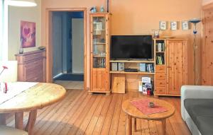 a living room with a flat screen tv and wooden furniture at Knueppelhof 2 in Silz