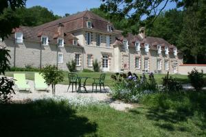 a large house with chairs and a table in front of it at Manoir De Montflambert in Mutigny