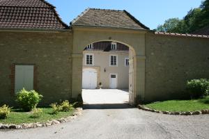 uma casa com um arco e uma garagem em Manoir De Montflambert em Mutigny