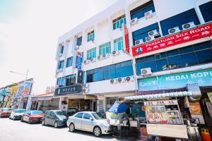 a street with cars parked in front of a building at Swing & Pillows - Penang Road, Georgetown Penang in George Town
