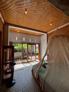 a bedroom with a bed with a mosquito net at THE NYAMO surfschool & stay in Pulukan +81 photos