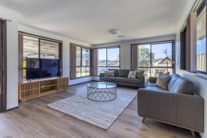 a living room with a couch and a tv at Bayt Baytak in Sussex inlet