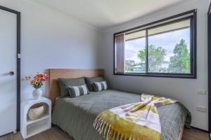 a bedroom with a bed and a large window at Bayt Baytak in Sussex inlet