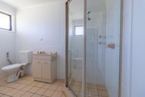 a bathroom with a toilet and a glass shower at Bayt Baytak in Sussex inlet +22 photos