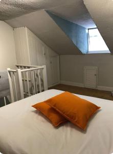un cuscino arancione su un letto in mansarda di Cost Loft Double Bedroom in shared house closer to city center a Reading 1 altra foto