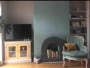 un soggiorno con sedia e camino di Cost Loft Double Bedroom in shared house closer to city center a Reading