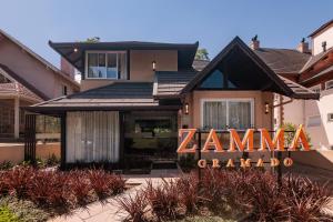a house with a zaminarmaarma sign in front of it at Pousada Zammá Gramado in Gramado