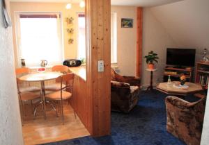 ein Wohnzimmer mit einem Tisch und einem Esszimmer in der Unterkunft Ferienwohnung Krug in Sassnitz