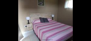 ein Schlafzimmer mit einem großen Bett und einer gestreiften Decke in der Unterkunft Waylla in Panaholma + 22 Fotos