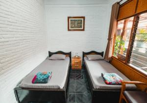 レギャンにあるTempo Doeloe Homestay Kutaの窓が2つある部屋にベッドが2つある