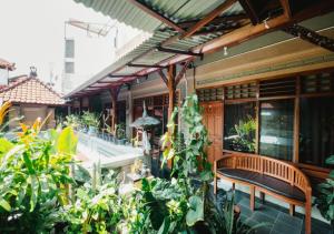 レギャンにあるTempo Doeloe Homestay Kutaの屋外パティオ(ベンチ、植物付)