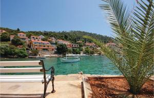 a bench sitting next to a body of water with a boat at 4 Bedroom Beautiful Apartment In Brna in Brna +19 photos