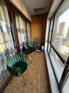 乌兰巴托Classic apartment at Circus的阳台配有桌椅和窗户。