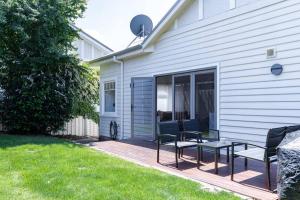 a patio with chairs and a table next to a house at Charming Family-Friendly Home in Kings Park