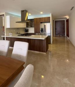 a large kitchen with white appliances and a table at Comfort at Club De Golf el Tigre in Nuevo Vallarta 