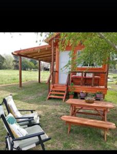 a picnic table and chairs in front of a cabin at Cabaña Don Juan in Villa Elisa +6 photos