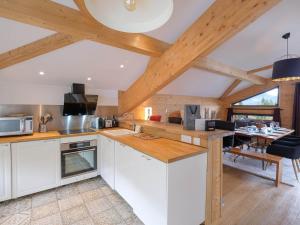 cocina con armarios blancos y comedor en Chalet spacieux pour 10 personnes à Crest-Voland avec vue panoramique - FR-1-809-9, en Crest-Voland
