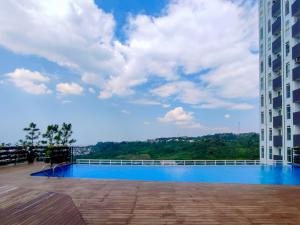スマランにあるFancy and Nice 1BR with Extra Room at Amartha View Apartment By Travelioの建物内のスイミングプールを望む