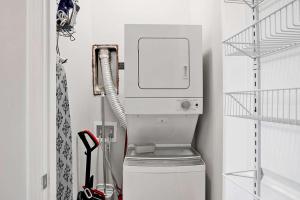 a washing machine in a laundry room with a phone at New! 1 BR Renovated Apartment in the Heart of downtown in Mobile