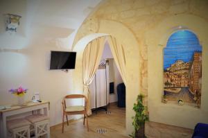 a living room with an archway and a table and chairs at Al Borgo dell'Arte Suite in Scicli