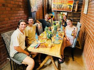een groep mensen die rond een tafel zitten bij Savannah House in Arusha