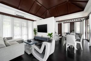 a living room with a couch and a tv at Renovated Luxury 3 Bed Pool Villa Kirikayan Maenam Koh Samui in Amphoe Koh Samui