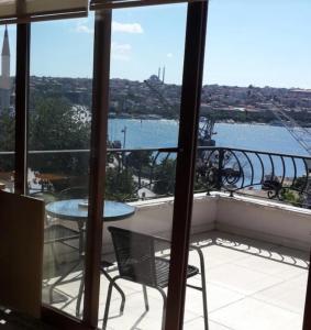 een balkon met een tafel en uitzicht op het water bij Galatolia Otel in Istanbul