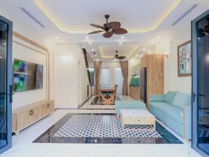 a living room with a blue couch and a ceiling at Sea Casa Ho Tram - Villa nghỉ dưỡng sát biển Hồ Tràm in Xuyên Mộc