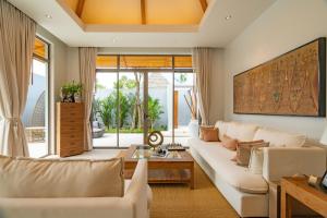 a living room with a couch and a table at Modern 3BR Pool Villa at Anchan Flora in Bangtao in Bang Tao Beach