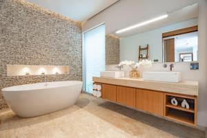 a bathroom with two sinks and a tub and a mirror at Modern 3BR Pool Villa at Anchan Flora in Bangtao in Bang Tao Beach