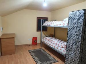 a room with two bunk beds and a wooden floor at Vila SCARLET Pielesti Dolj in Cîmpeni