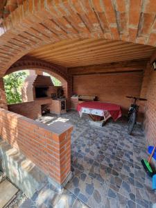 a room with a brick wall and a table and a bike at Vila SCARLET Pielesti Dolj in Cîmpeni