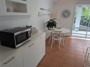 a kitchen with a microwave on a counter with a table at Sapphire Beach Pet Friendly Beach 5 minute walk in Sapphire Beach
