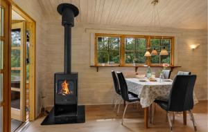 a fireplace in a dining room with a table and a stove at Two-Bedroom Holiday Home In Herning in Herning