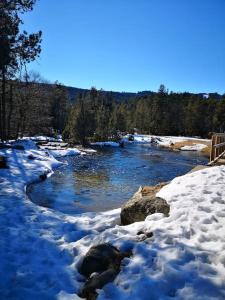 a river covered in snow with rocks and trees at Maison de montagne FONT ROMEU in Font Romeu Odeillo Via